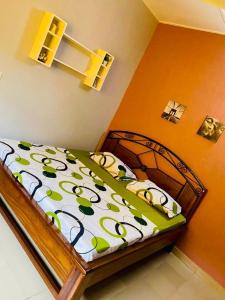 um quarto com uma cama com um edredão verde e branco em Cool meuble em Ouagadougou