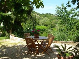 ein Tisch mit zwei Stühlen und ein Tisch mit Blumen darauf in der Unterkunft Il CASETTINO - Ferienwohnungen mit pool in Radicondoli