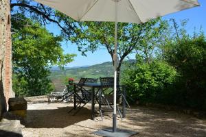 - une table et des chaises sous un parasol sur la terrasse dans l'établissement Ferienwohnung für 4 Personen ca 65 qm in Radicondoli, Toskana Provinz Siena, à Radicondoli