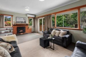 a living room with two couches and a fireplace at Rest & Relax villa Whangarei 4 Bedrooms 2 Bath family home in Whangarei