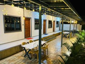 een restaurant met tafels en stoelen op een patio bij Kihim Paradise Beach & Resort in Alībāg