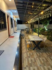 een patio met tafels, stoelen en verlichting bij Kihim Paradise Beach & Resort in Alībāg