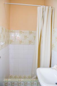 ein Bad mit einem Duschvorhang und einem Waschbecken in der Unterkunft Habitación en Chiclayo (Santa Victoria) in Chiclayo