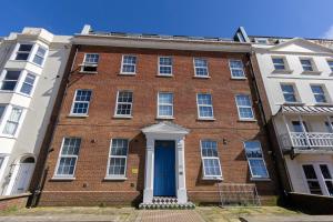 a large brick building with a blue door at Cosy Central 2 Bedroom - Near Brighton Beach & Shops! in Brighton & Hove