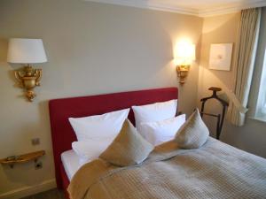 Habitación de hotel con cama con almohadas blancas en Ferienwohnung für 2 Personen ca 55 qm in Munkmarsch, Nordfriesische Inseln Sylt, en Munkmarsch