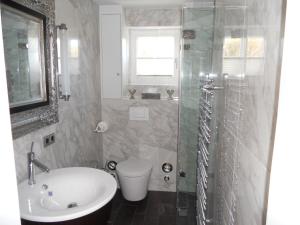 een badkamer met een wastafel, een toilet en een douche bij Ferienwohnung für 2 Personen ca 55 qm in Munkmarsch, Nordfriesische Inseln Sylt in Munkmarsch
