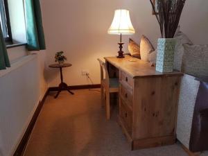 a room with a desk with a lamp on a dresser at Langford Executive Apartments in Bristol