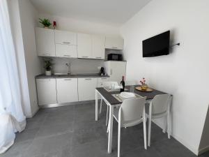 a kitchen with white cabinets and a table and chairs at Sacro Cuore Relais in Negrar