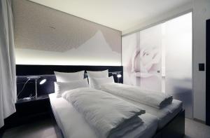 1 Schlafzimmer mit 2 Betten und weißer Bettwäsche in der Unterkunft Ferienwohnung für 5 Personen  1 Kind ca 65 m in Aschau im Zillertal, Tirol Nordtirol in Aschau