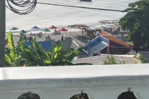 a view of a beach with umbrellas and the ocean at Dominica beach vacation rental in Méro