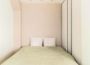 Bett in einem kleinen Zimmer mit weißen Wänden in der Unterkunft Le Saso in Lyon