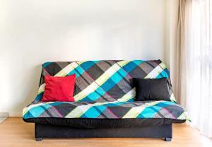 a couch with a colorful blanket on top of it at Le Saso in Lyon