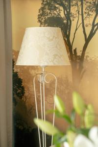 a lamp with a white shade next to a tree at Juvena Hotel Wellness & SPA Adults Only 12 plus in Międzywodzie