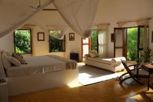 米查姆维的住宿－Dar Beach House - Michamvi，一间卧室配有一张床、一张沙发和窗户。