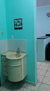 een badkamer met een wastafel en een blauwe muur bij Aluga-se casa com Piscina no Guarujá in Guarujá