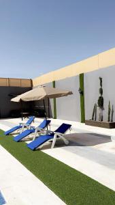 two lounge chairs and an umbrella next to a pool at الكرك زحوم in Kerak