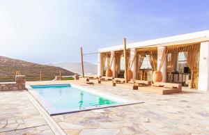 a swimming pool in front of a building with mountains at Villa Poppy private pool by opus in Mikonos