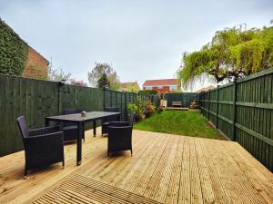 a patio with a table and chairs on a wooden deck at Haydon Hill House in Buckinghamshire