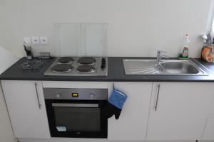 a kitchen with a stove top oven next to a sink at Location G&W, très proche sanctuaires II in Lourdes