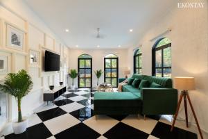 a living room with a green couch and a checkered floor at EKOSTAY Luxe - Casa Roma in Alibaug