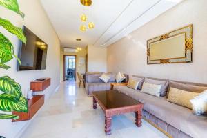 Chez taux في مراكش: غرفة معيشة مع أريكة وطاولة