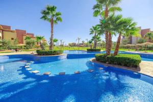 una piscina con palmeras en un complejo en Chez taux, en Marrakech