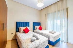 1 dormitorio con 2 camas y ventana en Chez taux, en Marrakech
