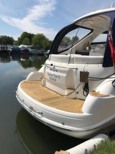 a boat with a wooden dock on the water at ENTIRE LUXURY MOTOR YACHT 70sqm - Oyster Fund - 2 double bedrooms both en-suite - HEATING sleeps up to 4 people - moored on our Private Island - Legoland 8min WINDSOR THORPE PARK 8min ASCOT RACES Heathrow WENTWORTH LONDON Lapland UK Royal Holloway in Egham