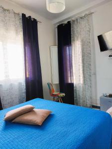 a bedroom with a blue bed with two pillows on it at La casa dei 4 venti in Ponza