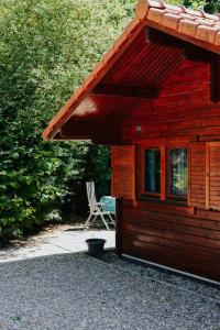 Cabaña de madera con silla y mesa en Sfeervolle blokhut met fijne buitenruimte @ Veluwe en Epe