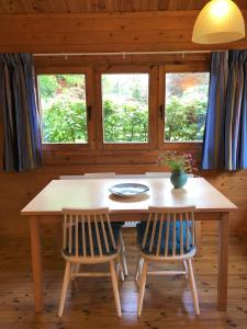 un tavolo in legno con due sedie e un piatto sopra di Sfeervolle blokhut met fijne buitenruimte @ Veluwe a Epe