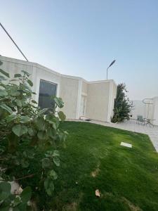 a house with a yard with a grassy yard sidx sidx sidx at شاليهات أوريجامي in Buraydah