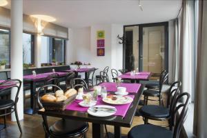un comedor con mesas y sillas púrpuras en Tandem Hotel, en Bamberg