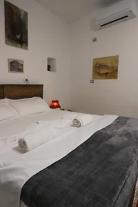 a bed with white sheets and towels on it at Edward Lear in Berat