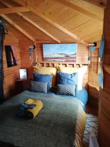SHERWOOD TREE في إتريتا: غرفة نوم في كابينة خشب بها سرير
