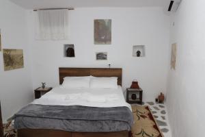 um quarto com uma cama grande e lençóis brancos em Edward Lear em Berat