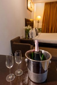 a bottle of wine in a bucket next to two wine glasses at Casabela Boutique Hotel in Porvorim