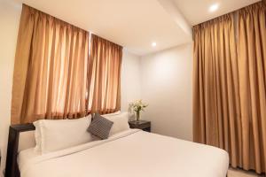 a bedroom with a white bed in front of a window at Casabela Boutique Hotel in Porvorim