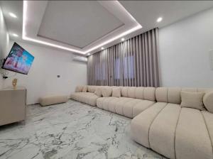 a living room with a large couch and a television at Villa turquoise in Mezraya