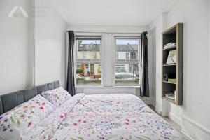 um quarto com uma cama e uma janela em Cosy Tottenham Apartment Sleeps 4 em Londres