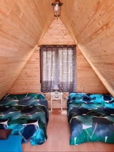 a room with two beds in a log cabin at Moara de Pădure in Cluj-Napoca
