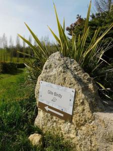 un cartel en una roca en un jardín en Gîte Birdy - Vue sur les Pyrénées, en Lamazère