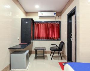 Habitación con silla, mesa y ventana en Hotel Suraj Inn, en Surat