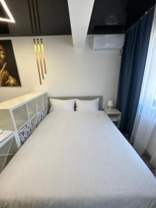 1 cama blanca grande en una habitación con ventana en Perla Home - Studio 9 en Popeşti-Leordeni
