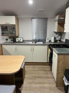 a kitchen with a sink and a stove top oven at Ataraxia - Ocean Edge Resort - 8 Berth Accommodation in Heysham