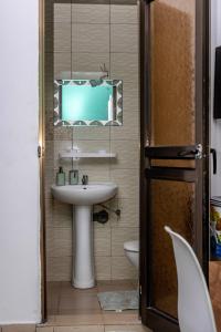 uma casa de banho com um lavatório e um espelho em APPARTEMENT KUAMINA em Lomé