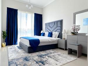 a bedroom with a large bed and blue curtains at Dunya Tower Luxury and 2 min walk to Dubai Mall and Burj Khalifa in Dubai