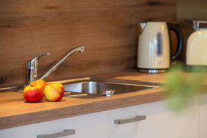 Una cocina con un fregadero y dos manzanas en una encimera. en Ferienwohnung Mopsfidel, en Pfronten
