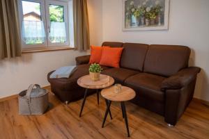sala de estar con sofá marrón y 2 mesas en Ferienwohnung Mopsfidel, en Pfronten