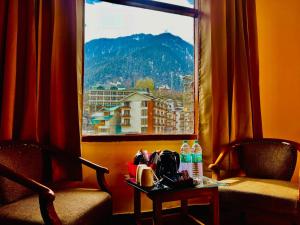 a room with a window with a table and two chairs at WooibHotels The Kalinga Palace Manali in Manāli